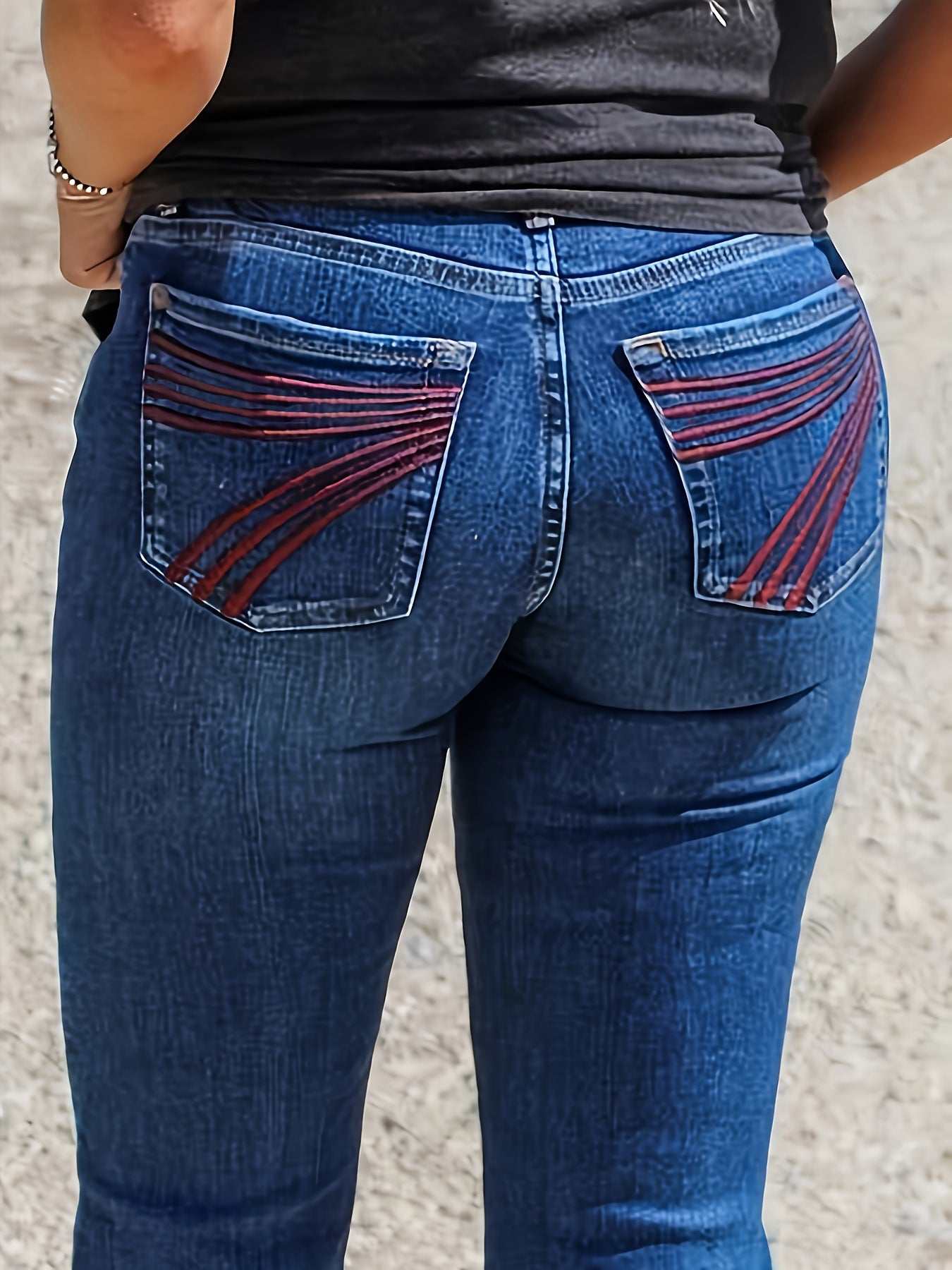 Slim fit elastic mid-waist denim jeans with red embroidery on back pockets, slightly flared design