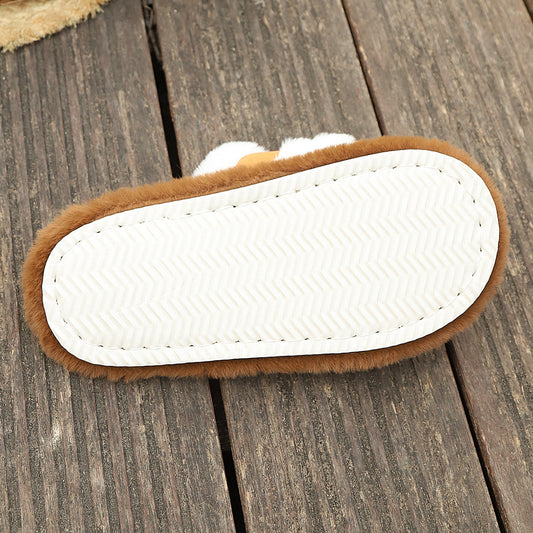 Bottom view of brown fluffy slippers with white EVA sole on wooden floor
