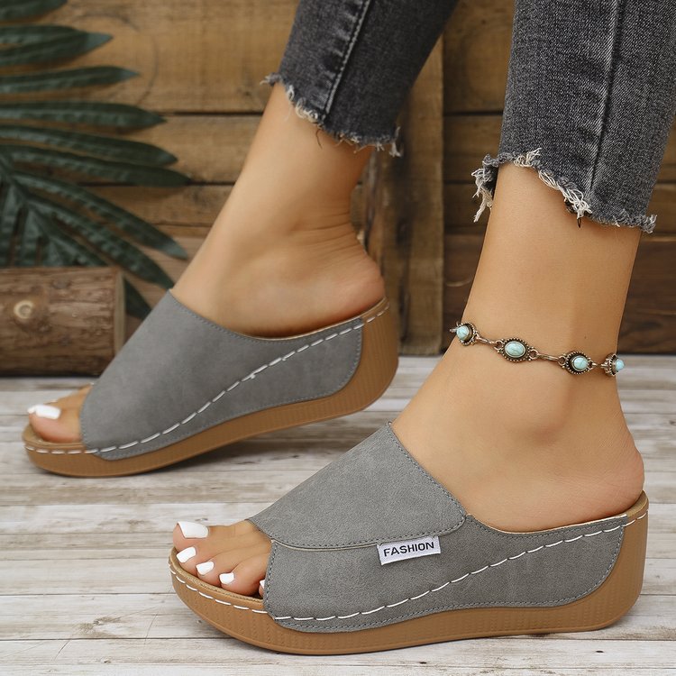 Grey summer wedge slides with fish mouth design and thick rubber sole on feet