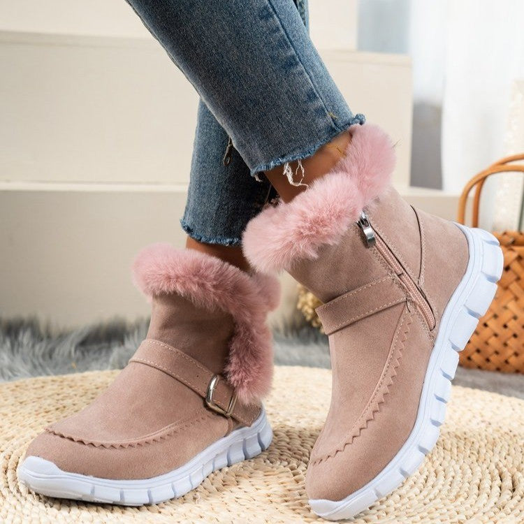 Pink winter snow boots with plush fur lining, buckle design, side zipper, and white rubber flat soles for women