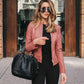 Women wearing autumn winter fashion pink PU leather jacket with zipper and shoulder-length hairstyle carrying black handbag outdoors