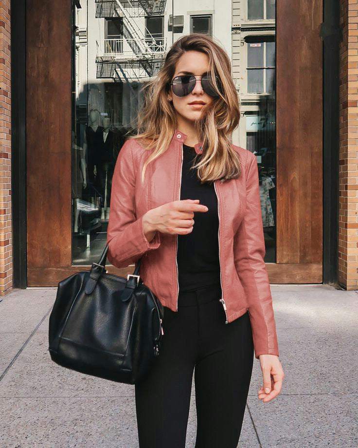 Women wearing autumn winter fashion pink PU leather jacket with zipper and shoulder-length hairstyle carrying black handbag outdoors