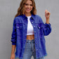Female model wearing a blue ripped shirt jacket with long sleeves and button-up front paired with jeans against a gray background