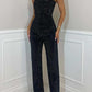 Woman wearing black shiny vest diamond trousers suit with strapless top and straight pants