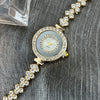 Diamond-encrusted glass rhinestone women's gold quartz watch on wooden surface