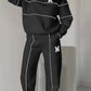 Women 2 piece black lounge sweatshirt and sweatpants set with white stripe details and pockets