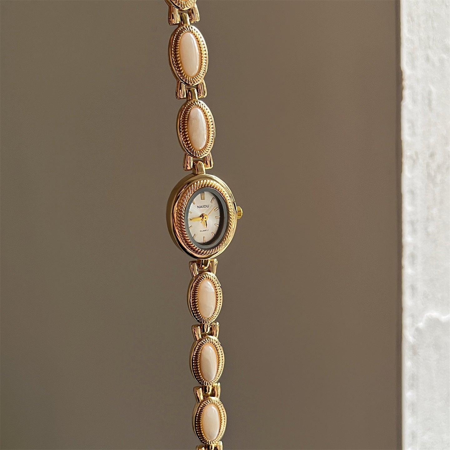 Women's agate bead bracelet watch with quartz movement and analog display in gold alloy.