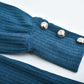 Close-up of blue ribbed cotton blend women's lapel pullover sleeve with three silver buttons