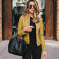 Woman wearing yellow PU leather jacket with zipper and black handbag outdoors, urban casual style women jacket