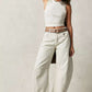 Women wearing high stretch mid-rise white wide leg casual denim jeans with a belt