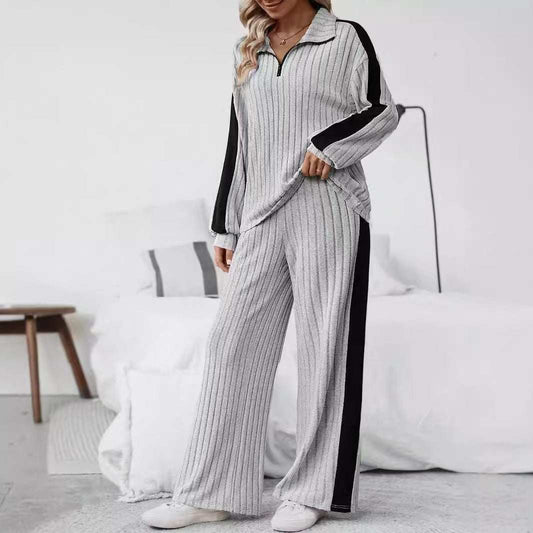 woman wearing casual suit women's sweater and wide leg pants set in gray with black stripes standing indoors