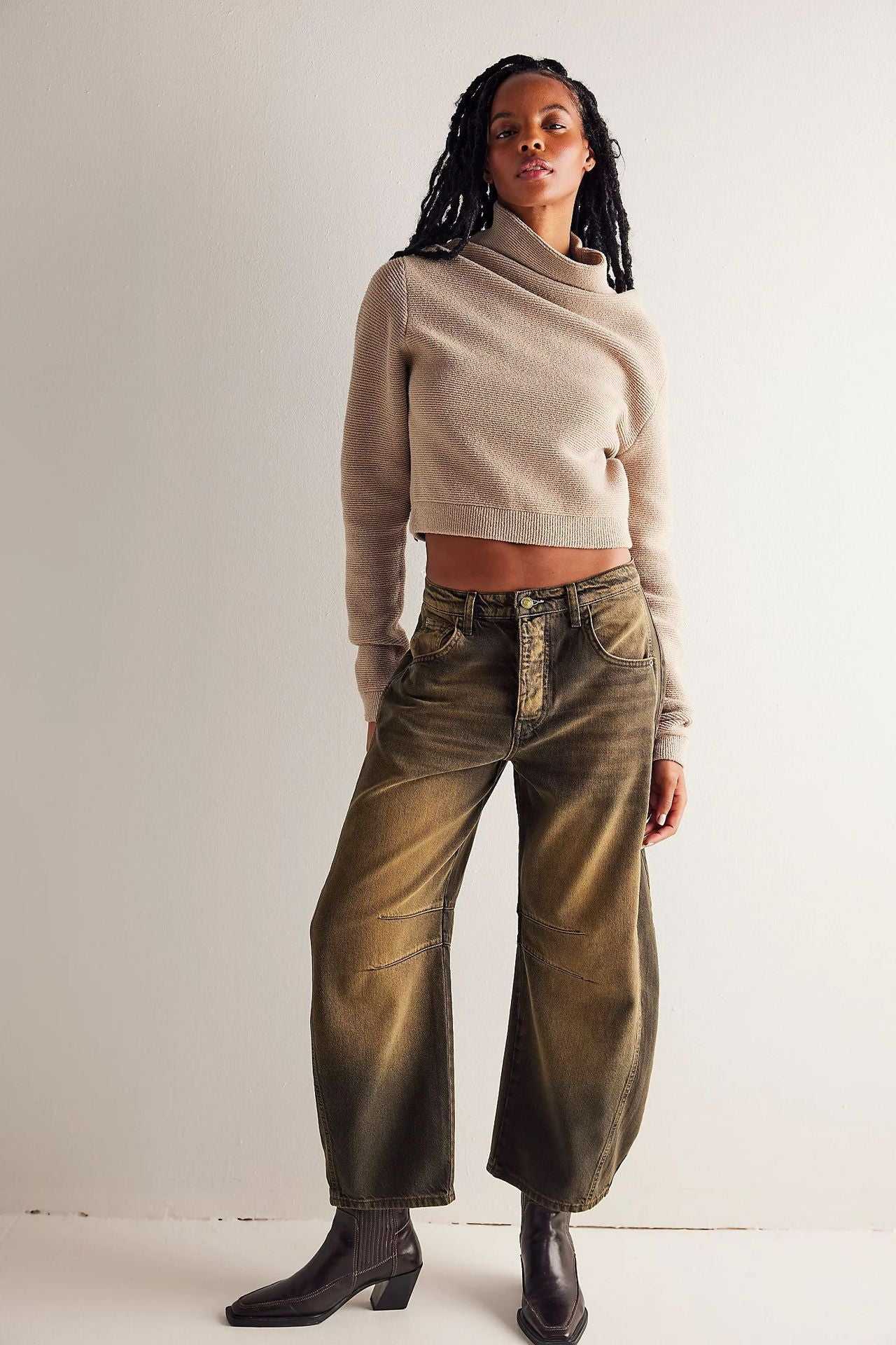 Woman wearing high stretch mid-rise loose wide leg denim jeans with brown wash and beige cropped sweater