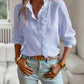 Woman wearing light blue striped long sleeve shirt with ruffle design and button-up front, styled casually with light washed jeans indoors