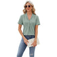 Woman wearing a green V-neck hollow design summer loose short-sleeved T-shirt with blue jeans and sunglasses