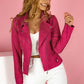 woman wearing bright pink zip-up lapel jacket with pockets against pink background