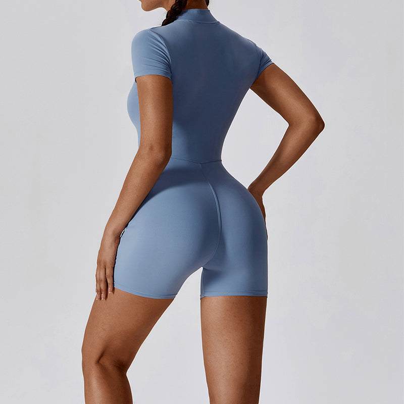 Woman wearing haze blue zipper short sleeve yoga jumpsuit with tight waist-length fit and pullover style