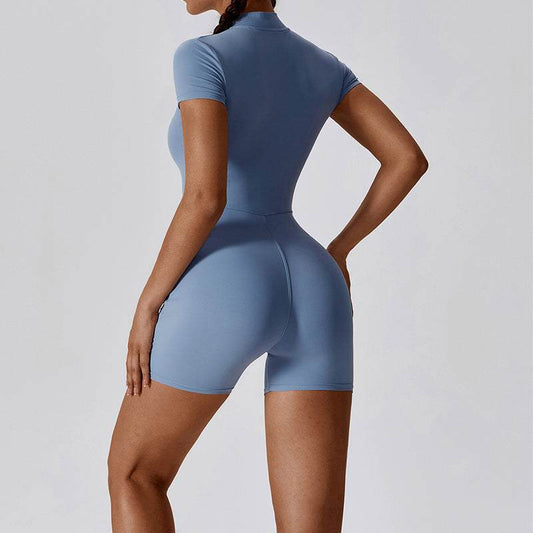 Woman wearing haze blue zipper short sleeve yoga jumpsuit with tight waist-length fit and pullover style