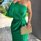 Woman wearing army green women's diagonal shoulder knot split solid color slim fit dress with one long sleeve and side slit holding a woven clutch purse outdoors