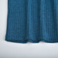 Close-up of blue cotton blend ribbed knit fabric on women's lapel pullover sweater hem