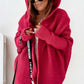 Woman wearing oversized loose bat sleeve hooded cardigan in red pink color