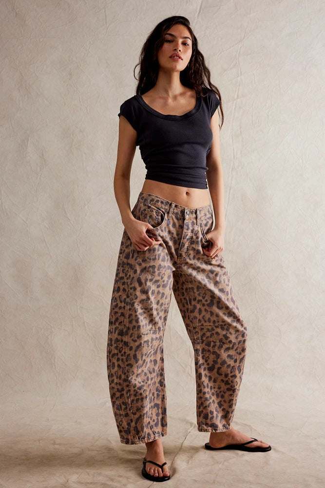 Woman wearing high stretch mid-rise wide leg leopard print jeans with black cropped t-shirt and flip-flops