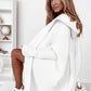 Woman wearing oversized white bat sleeve hooded cardigan sweater indoors