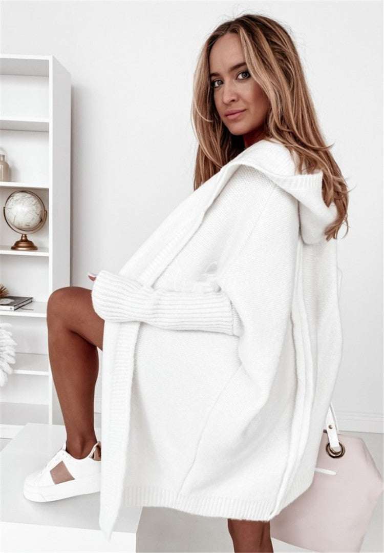 Woman wearing oversized white bat sleeve hooded cardigan sweater indoors