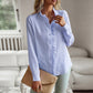 woman wearing light blue striped long sleeve shirt with ruffle design and button up front, casual office blouse
