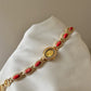 Women's agate bead bracelet watch with gold alloy and analog quartz movement on white fabric background