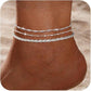 Silver layered beach anklet with stars, hearts, pearls, and round beads on ankle at sandy beach