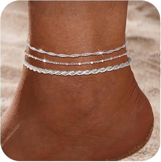 Silver layered beach anklet with stars, hearts, pearls, and round beads on ankle at sandy beach