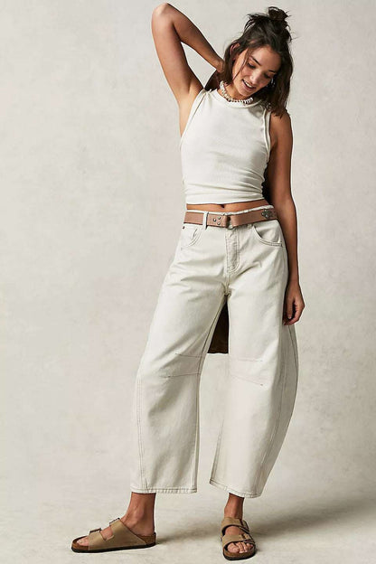 Woman wearing high stretch mid-rise wide leg barrel jeans in white with casual tank top and sandals