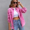 Woman wearing pink ripped shirt jacket with frayed edges and blue jeans, casual autumn spring top