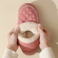Pink winter plush cotton shoe with thick rubber sole and soft fleece lining held by hands