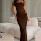 Woman wearing brown Y2K lace suspender dress standing indoors near sofa