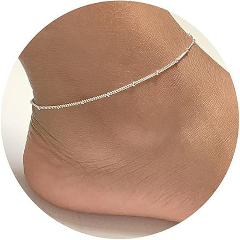 Delicate silver beach anklet with tiny beads on ankle