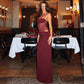 Woman wearing burgundy Y2K lace suspender dress with cut-out lace sides at elegant restaurant party