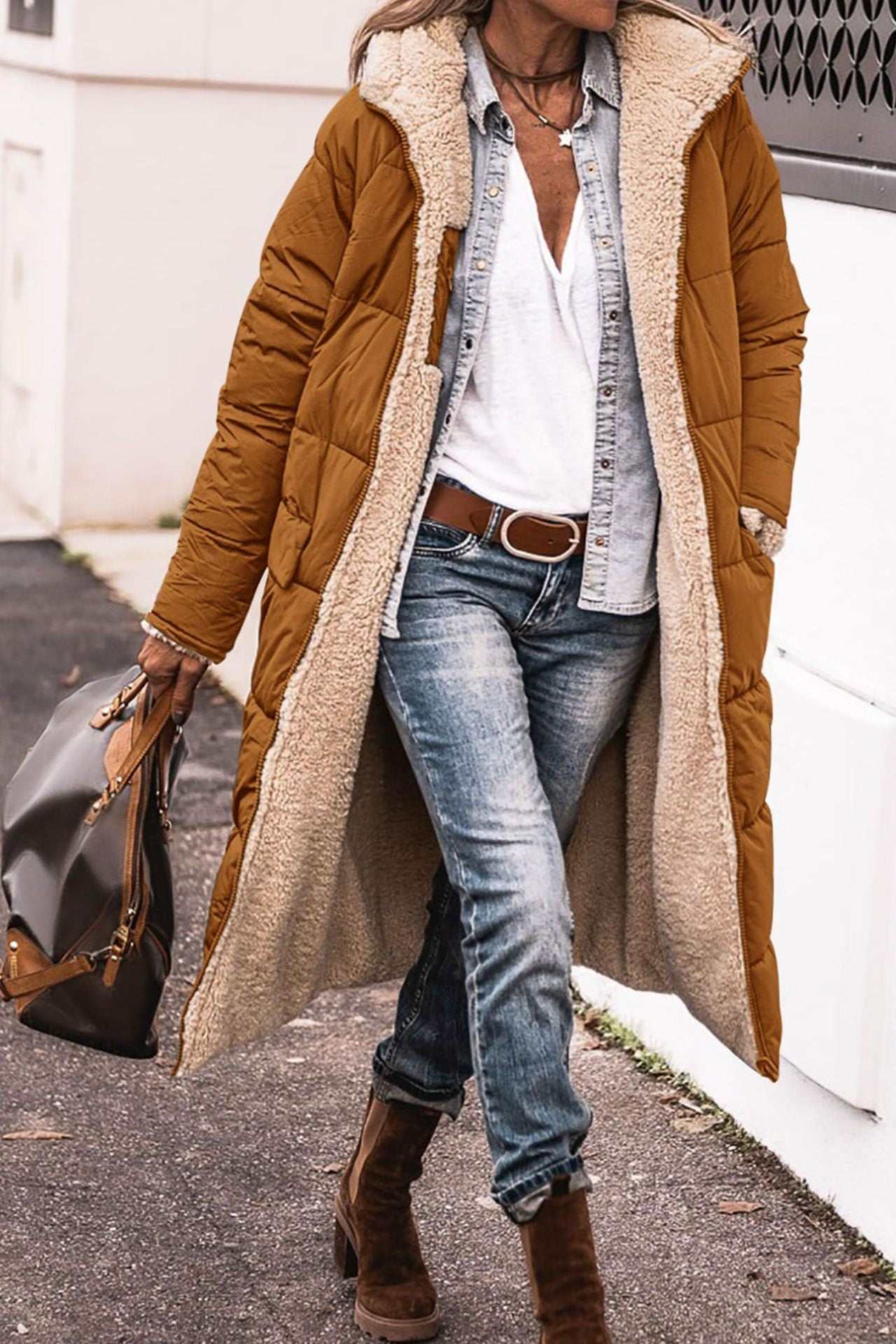 Woman wearing solid color hooded long winter coat with fur lining and pockets