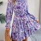 Woman wearing standing collar floral print long sleeve purple ruffled A-line dress with elastic waist and holding woven bag