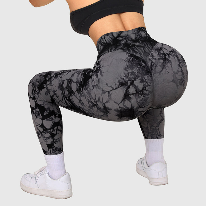 Women wearing black and gray seamless tie dye leggings squatting during workout