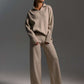 Woman wearing beige fall winter two piece set with loose collar sweater and wide-leg pants