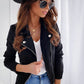 Woman wearing black slim fit zip-up lapel jacket with pockets and long sleeves, styled with sunglasses and hat