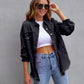 Female model wearing black ripped shirt jacket with rolled sleeves, white crop top, and blue jeans, casual autumn and spring fashion