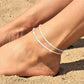sparkling silver double-layer beach anklet with tiny beads on sandy feet