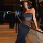 Woman wearing a black Y2K lace suspender dress with sheer lace midsection at an indoor stairway, stylish party evening clubwear