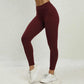 Women wearing seamless high waist yoga pants in solid maroon color with scrunch butt design and white sneakers