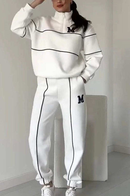 Women’s white 2 piece lounge sweatsuit with pullover sweatshirt and baggy pants with pockets, striped design, polyester fabric