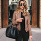 Women wearing brown PU leather jacket with zipper and carrying black handbag outdoors