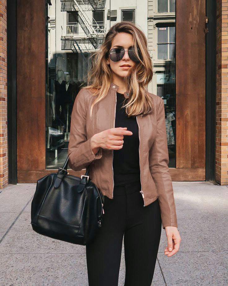 Women wearing brown PU leather jacket with zipper and carrying black handbag outdoors