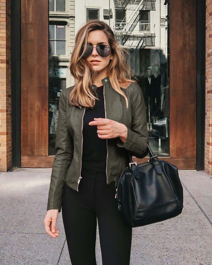 Woman wearing an urban casual leather PU suit jacket in army green with zipper and stitching details, holding a black handbag.